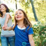 Frau und Kind spazieren fröhlich in der Natur