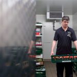 Der behinderte Mitarbeiter Marcel holt frisches Obst und Gemüse aus dem Lager des EDEKA-Marktes.